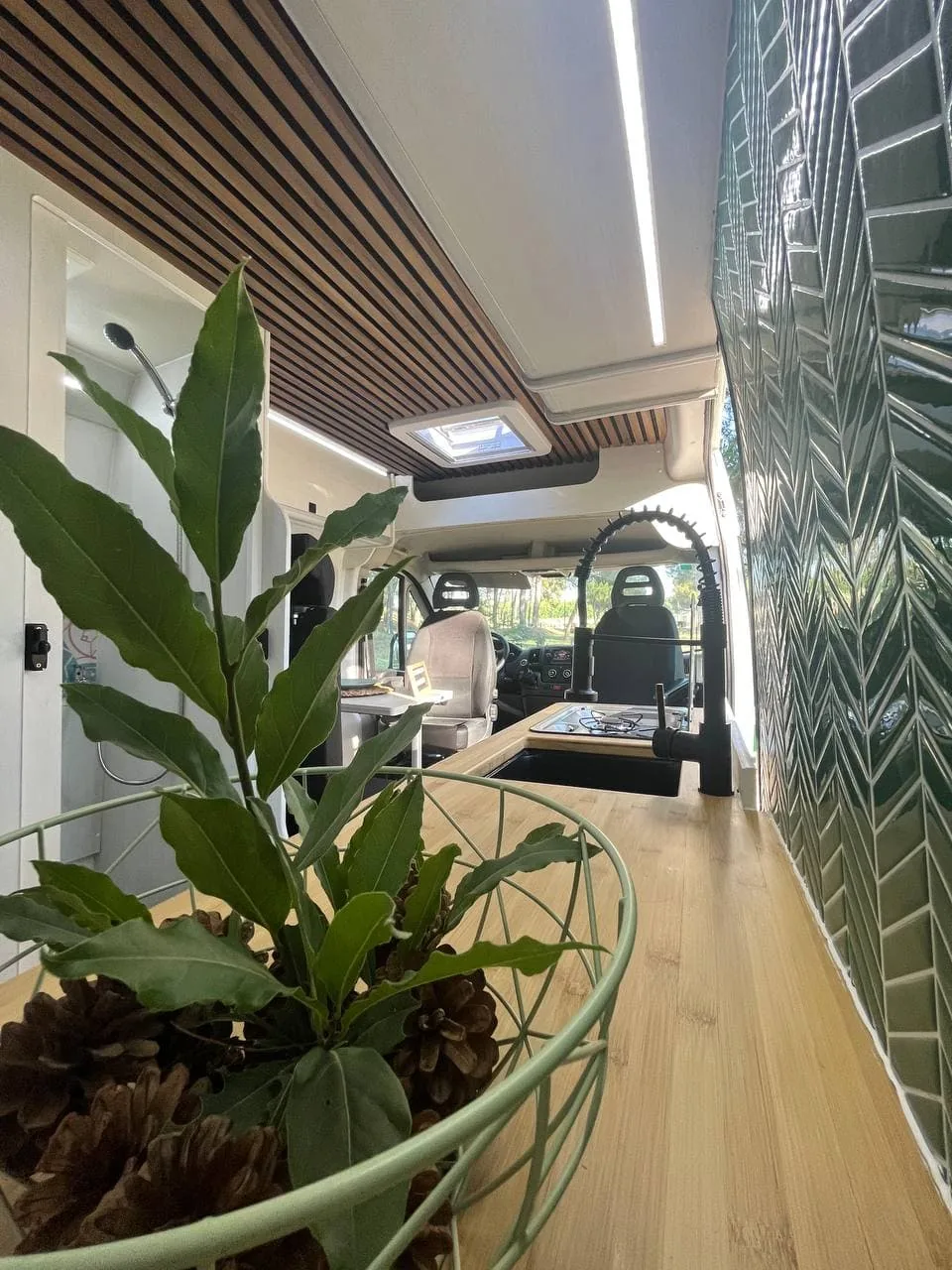 Interior equipado de una furgoneta camper de alquiler con cocina, salón y acabados en madera