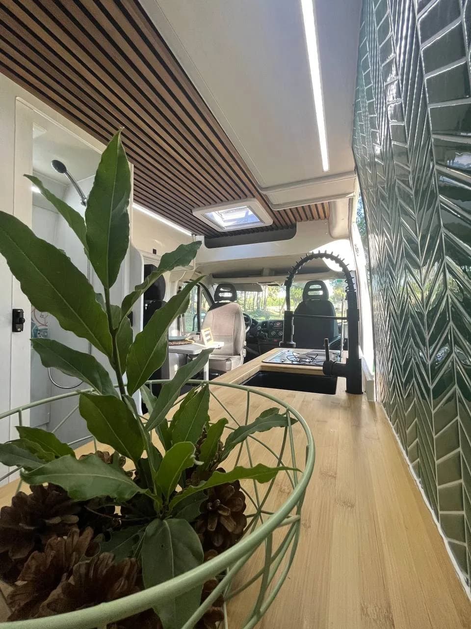 Interior equipado de una furgoneta camper de alquiler con cocina, salón y acabados en madera
